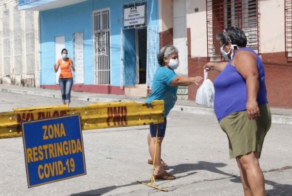 A woman hands over supplies to someone in a restricted area 