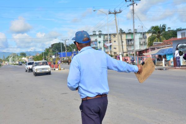 A traffic inspector waves at a car in order to make it stop